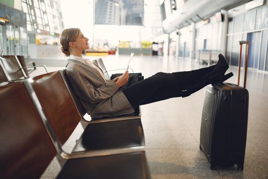 Traveller relaxing in an airport lounge with luggage