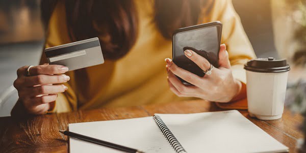 woman holding phone and credit card